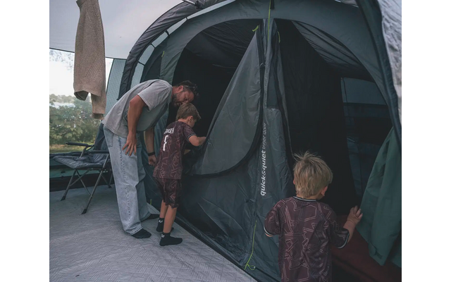 Eine Frau öffnet den Eingang eines Zeltes, zwei Kinder stehen davor