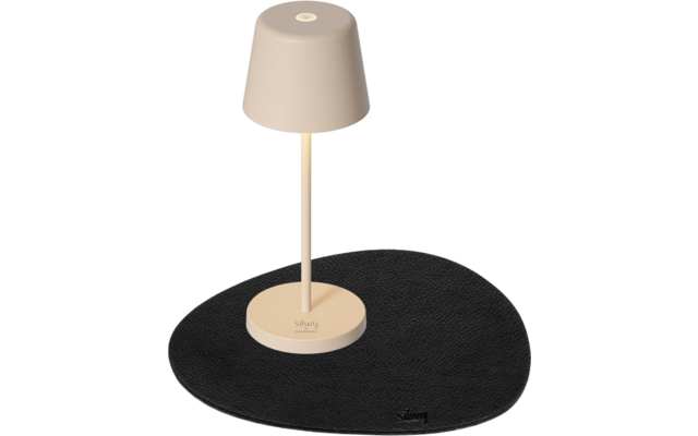 Beige Tischlampe auf einem schwarzen, unregelmäßig geformten Unterlage