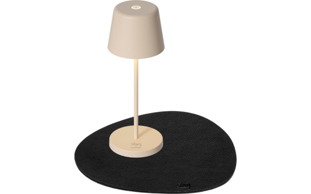 Beige Tischlampe auf einem schwarzen, unregelmäßig geformten Unterlage