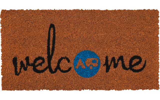 Braune Fußmatte mit schwarzem Schreibschriftzug 'welcome' und blauem Kreis mit orangefarbenen Buchstaben 'AP'