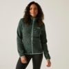Frau mit lockigem Haar, die eine grüne Jacke mit Reißverschluss trägt