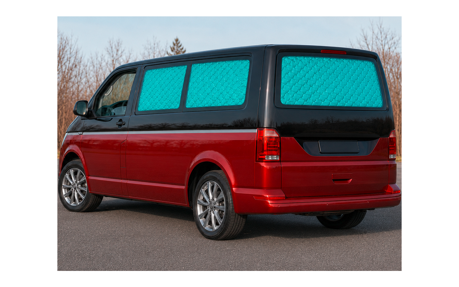 Red van, blue quilted window covers, parked on a road; leafless trees and sky in the background