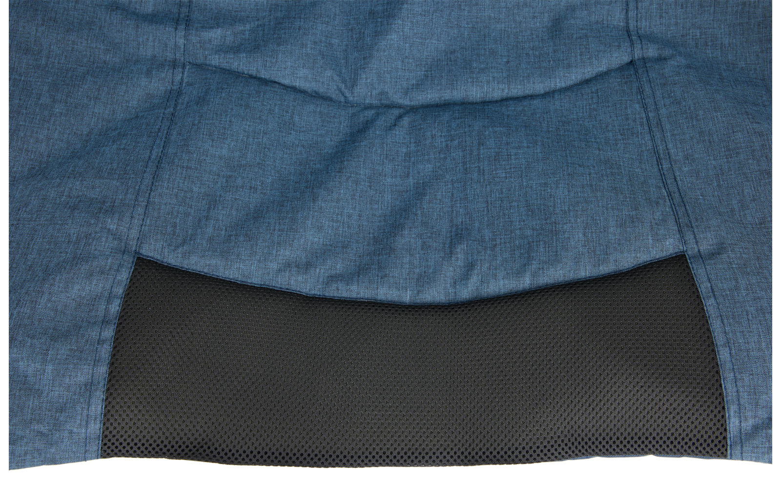 Blauer Stoff mit sichtbaren Nähten über einem schwarzen, fein strukturierten Paneel