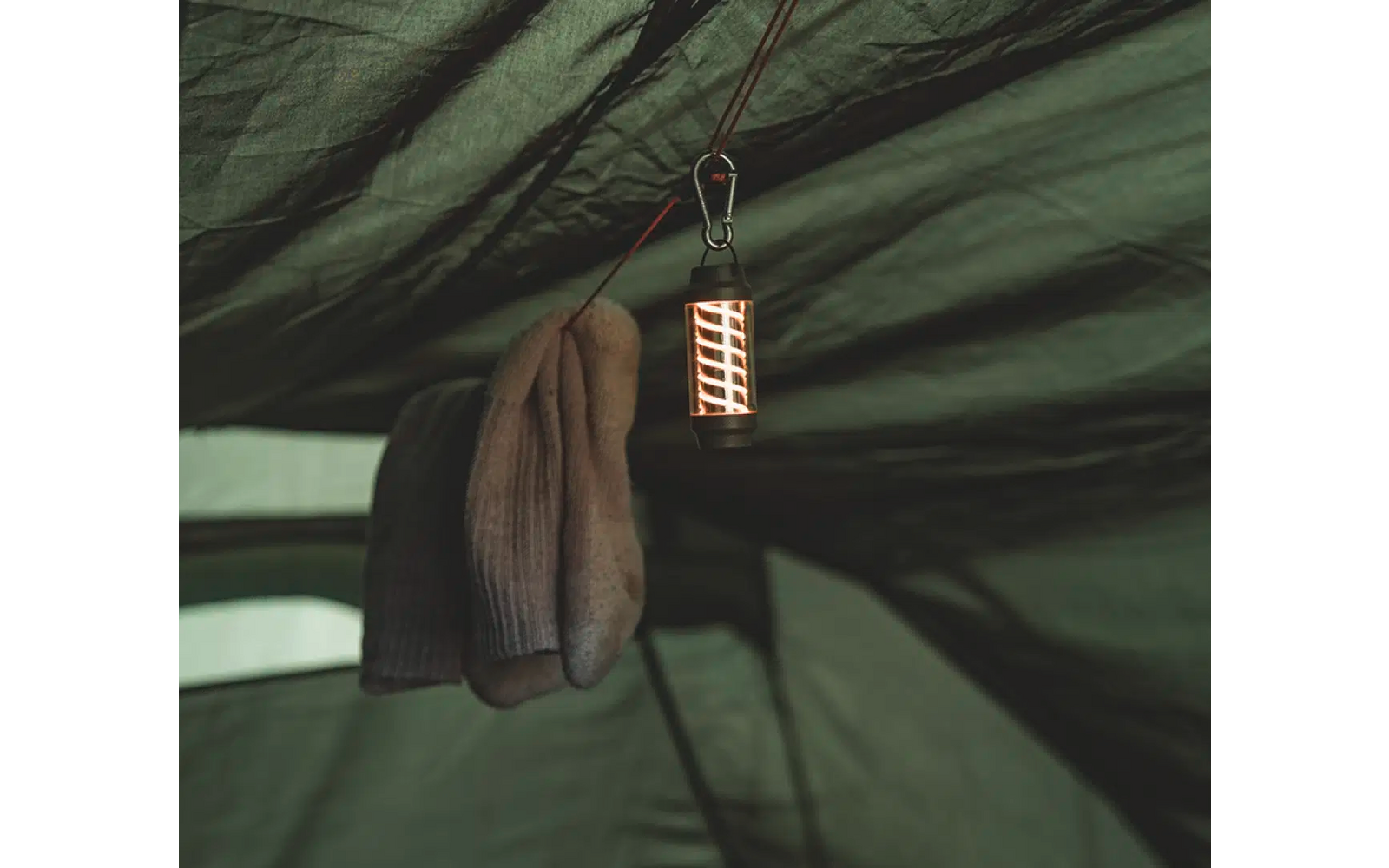 Ein Handtuch hängt an einer Schnur unter einem grünen Zelt