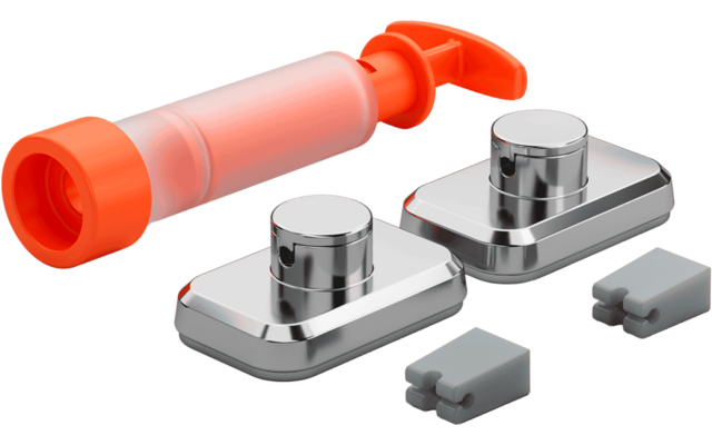 Orange translucent plastic cylinder with pump head, two chrome rectangular bases with round buttons, and two small grey plastic clips