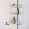 Three-tier metal corner shelf in a shower; on the shelves a yellow bar of soap, a green bottle, a green pump bottle, and a white cloth; left a shower control knob, right a glass door with black frame