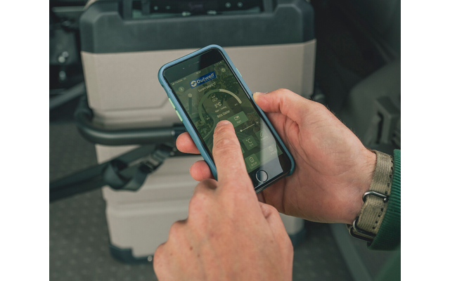 Zwei Hände halten ein Smartphone mit blauem Schutzcase, ein Zeigefinger berührt den Bildschirm, im Hintergrund eine graue Transportbox