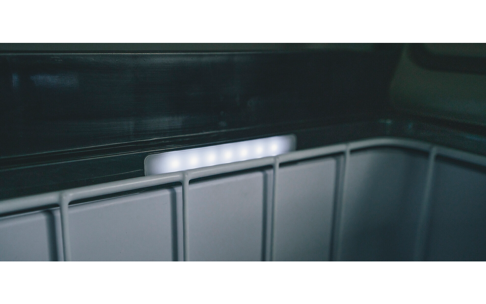 Innenraum eines Kühlschranks mit eingeschaltetem Licht und leeren Fächern