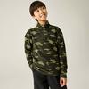 Junge in grünem Camouflage-Fleecepullover mit halbem Reißverschluss, Hände in den Taschen, schaut nach oben rechts vor hellem Hintergrund