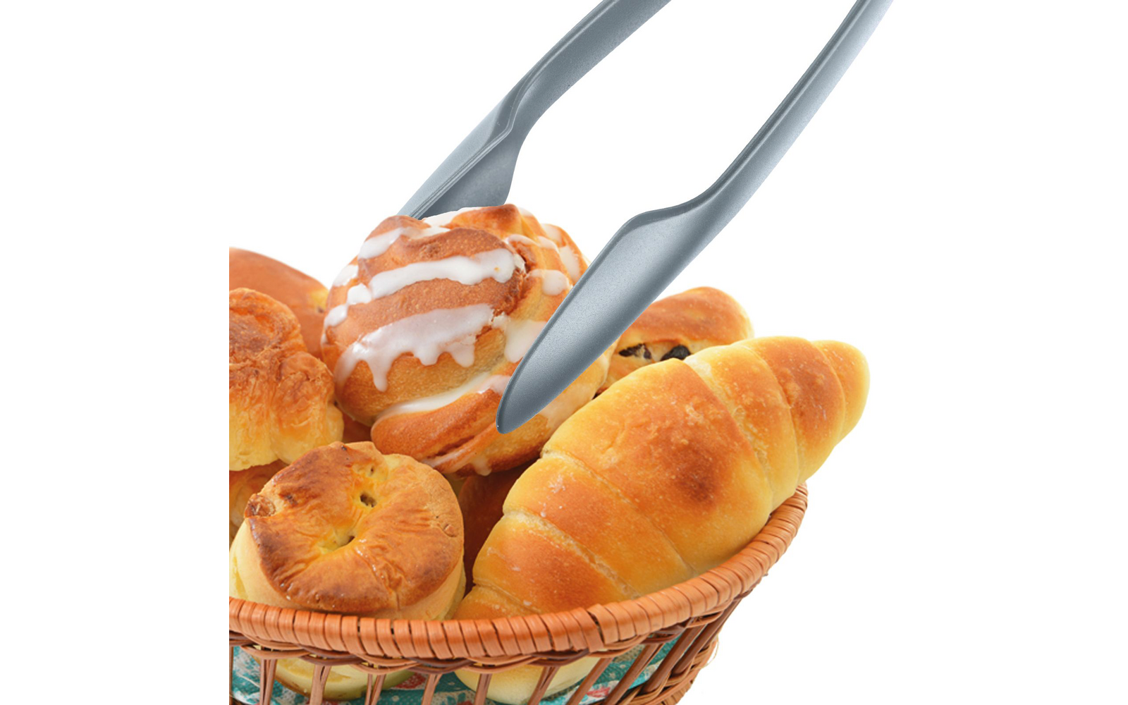 Panier en osier contenant divers petits pains et viennoiseries ; pince en métal tient une viennoiserie avec glaçage blanc ; fond blanc