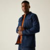 Ein Mann trägt ein dunkles Hemdjacke über einem orangefarbenen Pullover