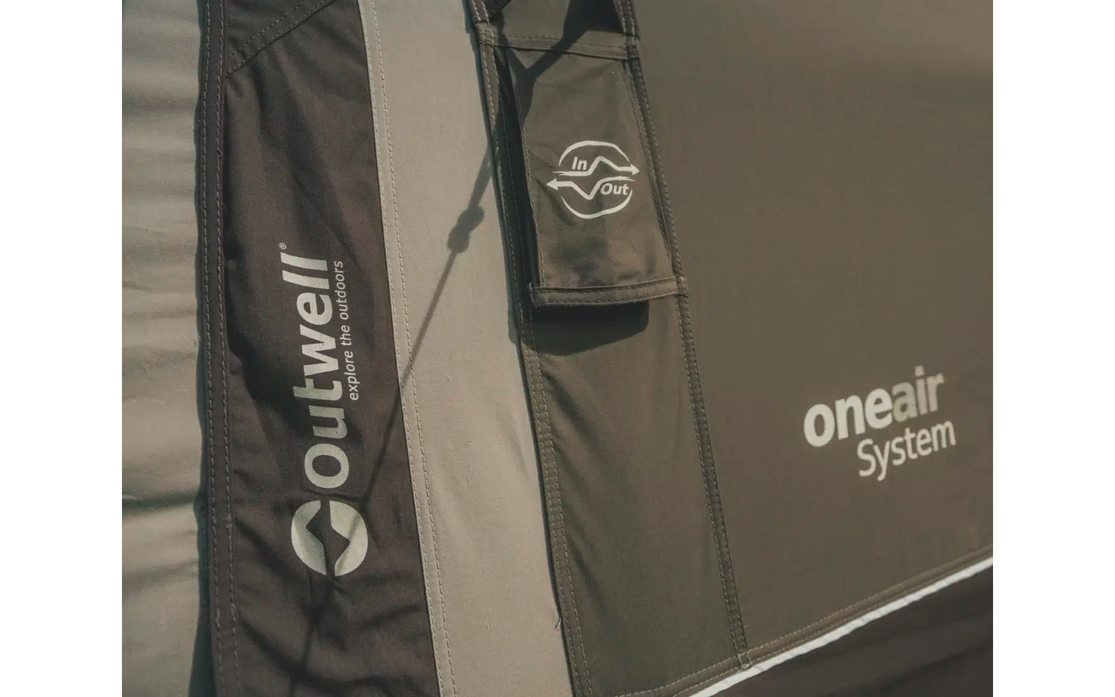 Zwei schwarze Jacken mit Logos von Marken, eine steht aufrecht, die andere liegt flach