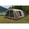 Large brown and beige tent with multiple windows on grass beside a lake and trees