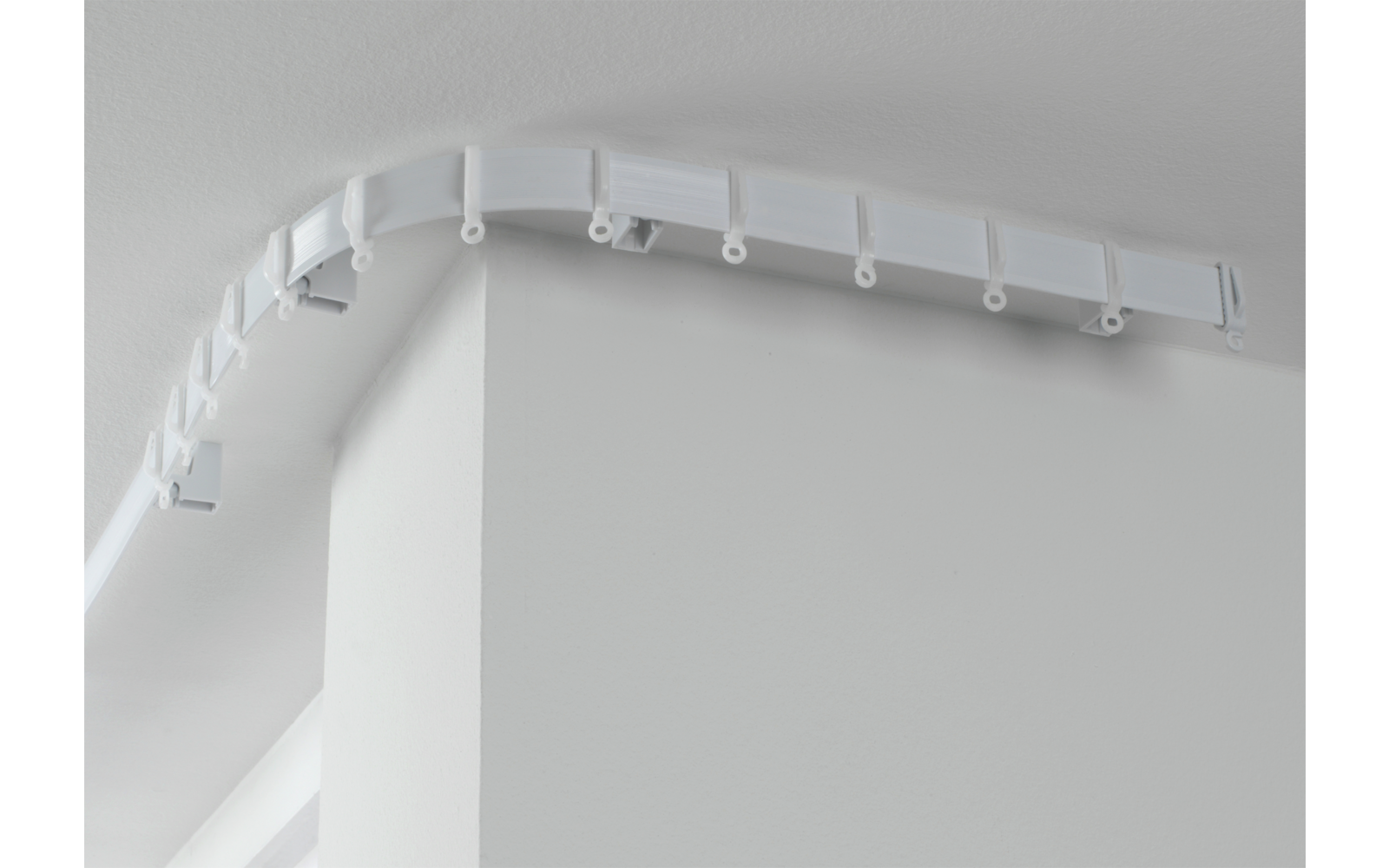 Weiße Ecke einer Wand mit weißem Kabelkanal an der Decke