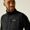 Porträt einer lächelnden männlichen Person von Brust bis Kopf, trägt eine schwarze Jacke mit gesteppter Vorderseite und Reißverschluss, sichtbares Logo Regatta Great Outdoors