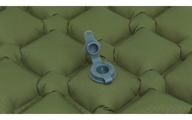 Aufgeblasene grüne Luftmatratze mit geöffnetem Ventil