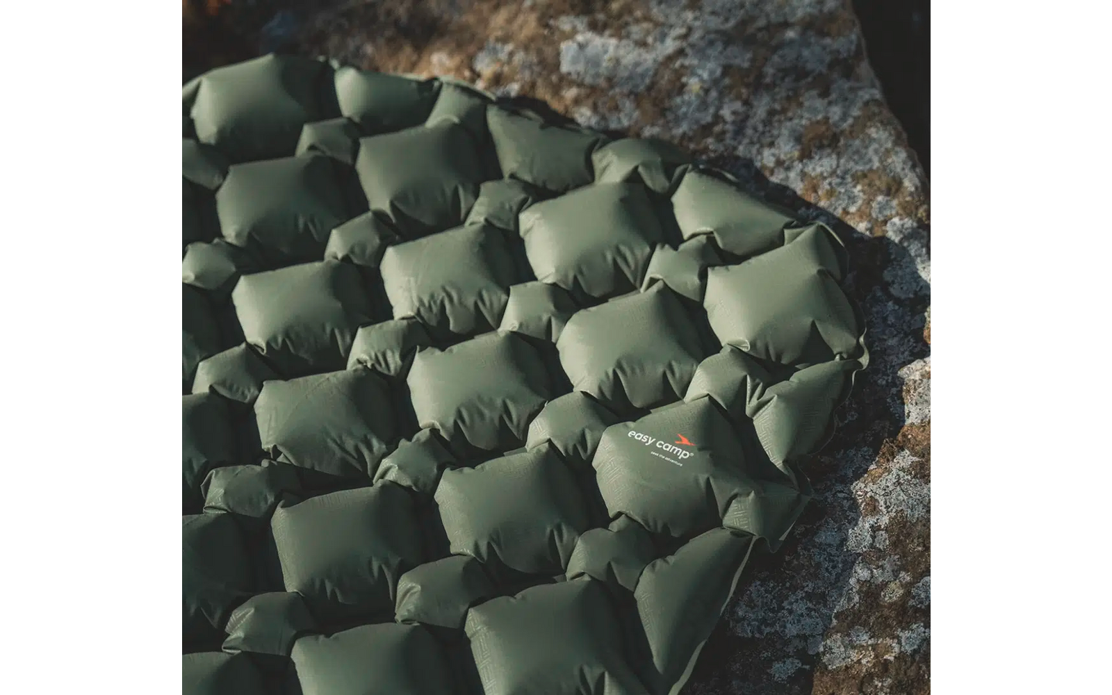 Aufgeblasene grüne Isomatte auf einem Felsen