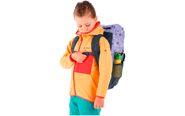Jongen met een oranje-rode trui en rugzak die naar een borstzak kijkt