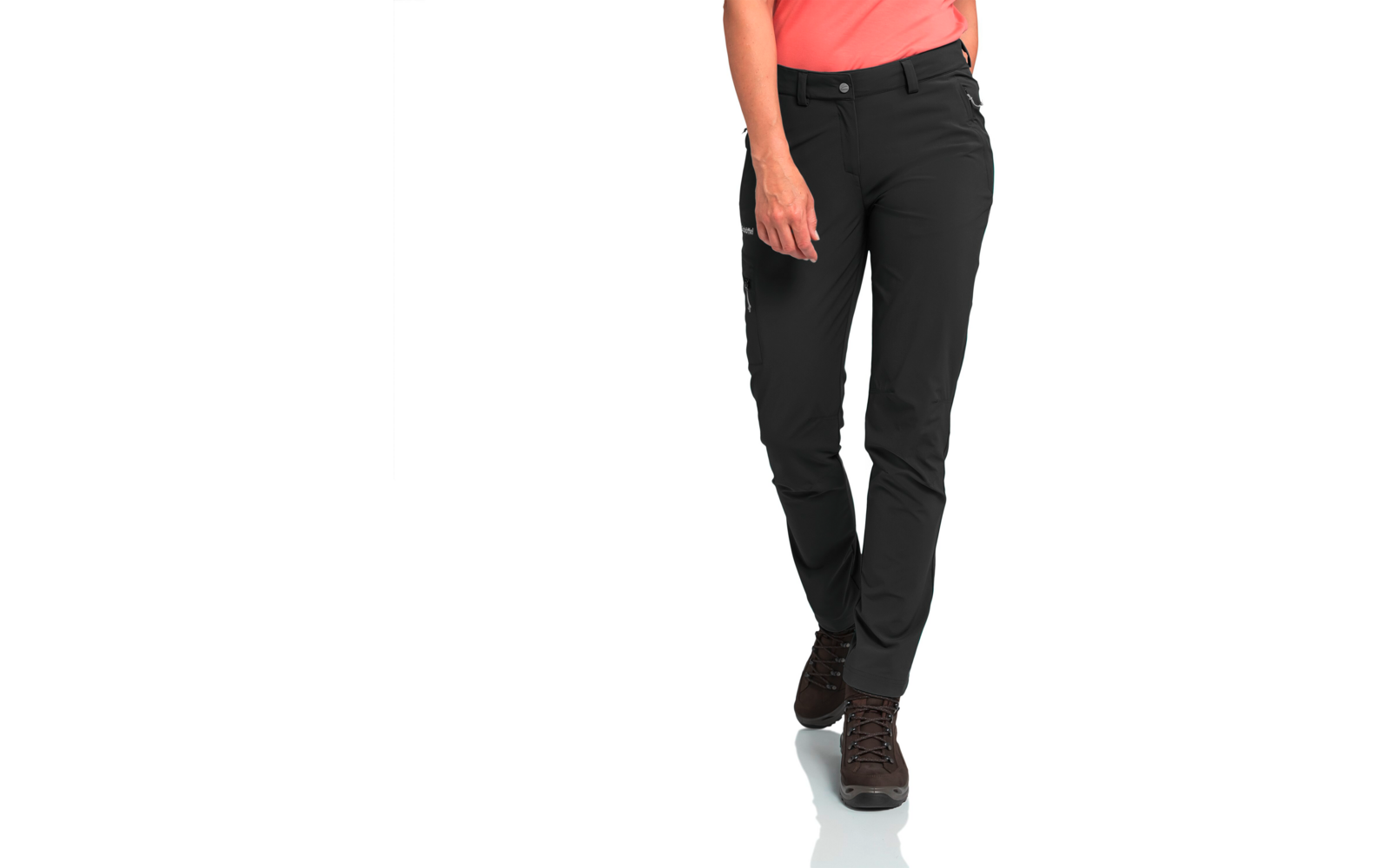 Teilansicht einer Person von der Taille abwärts mit schwarzer Hose, korallfarbenem Oberteilansatz, sichtbarer rechter Hand und braunen Schnürschuhen auf weißem Hintergrund