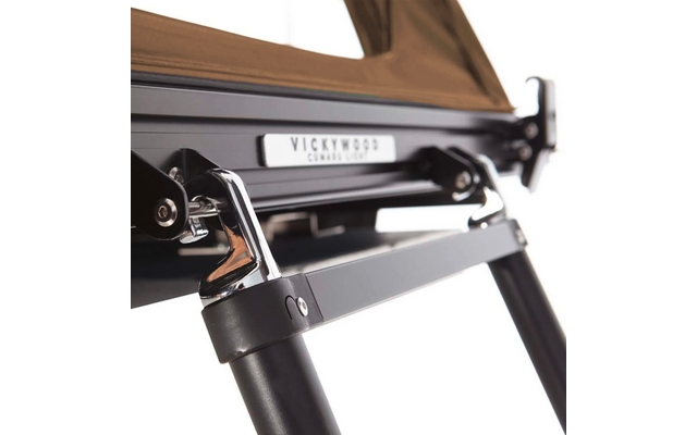 Nahaufnahme des Metallgestells eines Klappstuhls mit Metallplakette und braunem Stoff