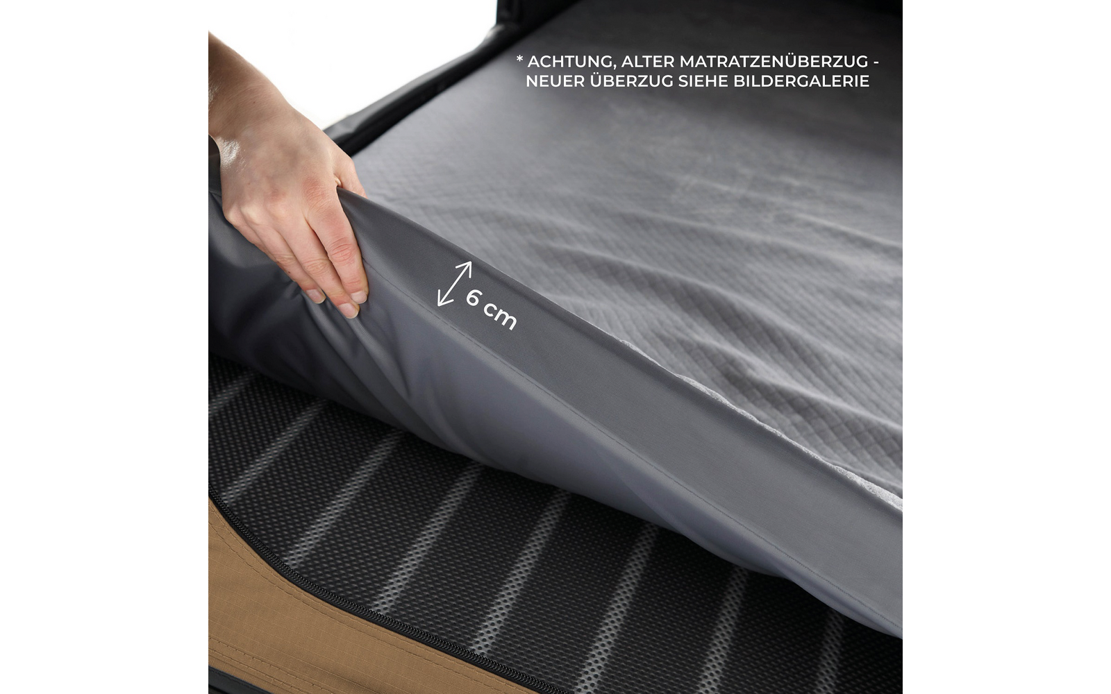 Hand hebt graue Matratzenschutzhülle an, weiße Pfeilmarkierung ‚6 cm‘ sichtbar, schwarze gestreifte Matratzenfläche mit brauner Kante, weißer Hinweistext oben rechts: 'ACHTUNG, ALTER MATRATZENÜBERZUG - NEUER ÜBERZUG SIEHE BILDERGALERIE'