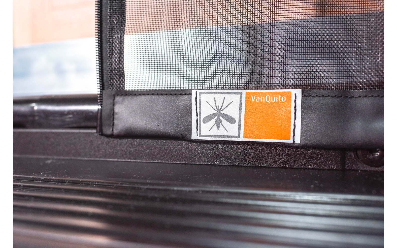 Nahaufnahme eines Treppengeländers mit zwei Aufklebern, einer schwarz-weiß und einer orange-weiß