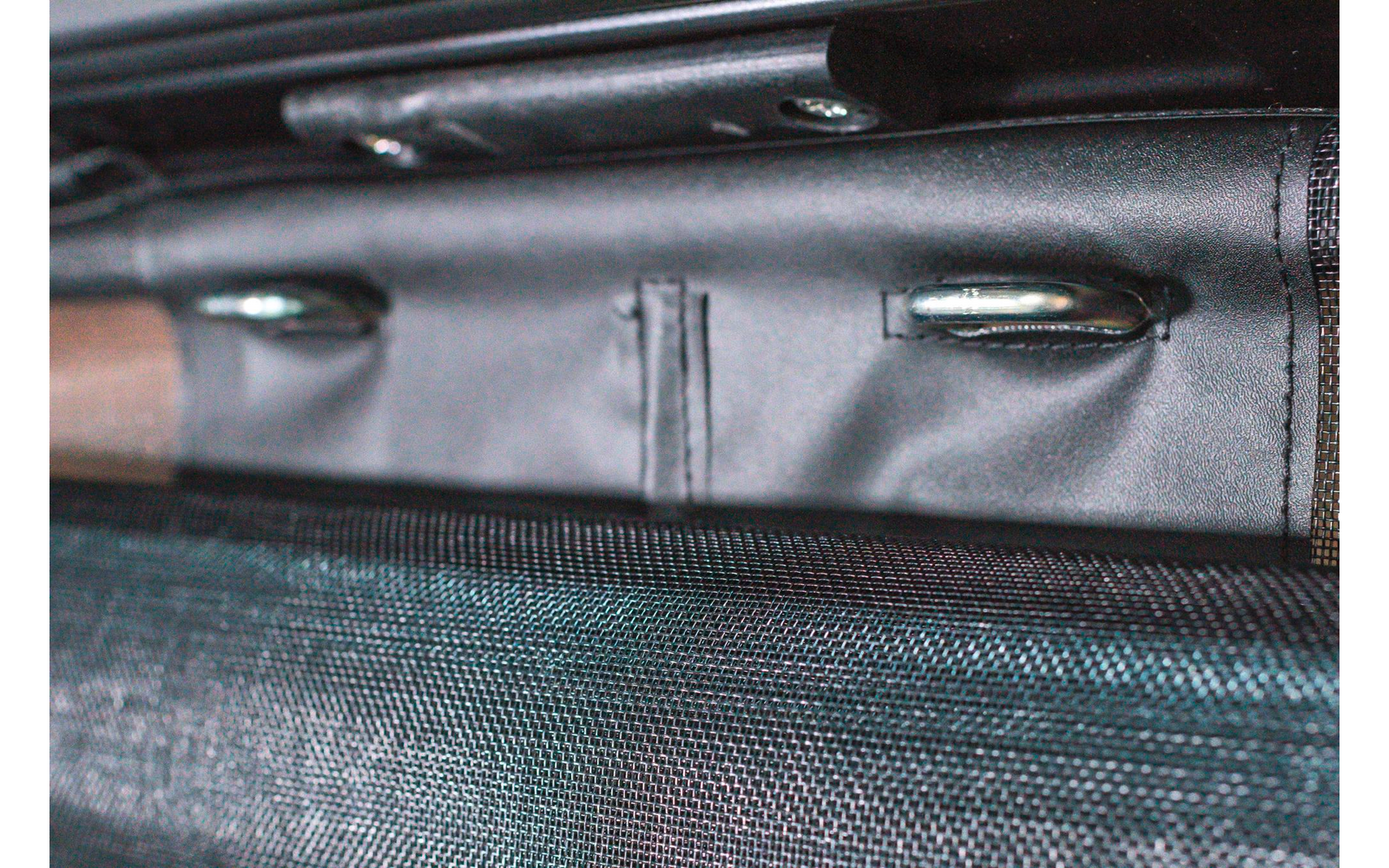 Nahaufnahme von metallischen Gegenständen und einem schwarzen Seil auf einem grünen Untergrund