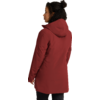 Persona con cabello oscuro y rizado recogido en un moño, vista de espaldas en ligero perfil hacia la izquierda, viste un abrigo rojo con capucha y pantalones negros