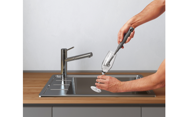 Hand vult glas met water uit keukenkraan