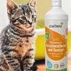 Braun-schwarz getigertes Kätzchen neben einer weißen Flasche mit orange-weißem Etikett 'awiwa pet Mikrobiologischer Geruchsentferner und Reiniger', vor einem gelben Kunststoffbehälter