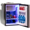 Kleiner geöffneter Kühlschrank mit blauer Innenbeleuchtung; in der Tür oben drei Coca‑Cola-Dosen, in der Türablage unten drei blaue Wasserflaschen; innen oben Gefrierfach, auf den Regalen verpackte Lebensmittel und ein Glas, ein rundes rotes Objekt, 