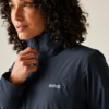Femme aux cheveux bouclés portant une veste bleu foncé et tenant le col avec la main