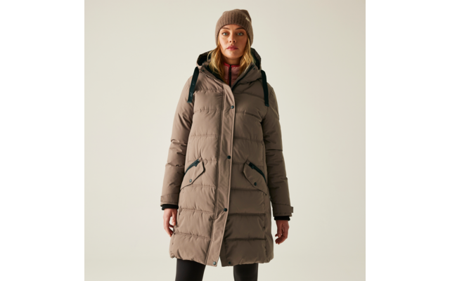 Frau trägt lange beige Winterjacke mit Kapuze und schwarzen Rucksack