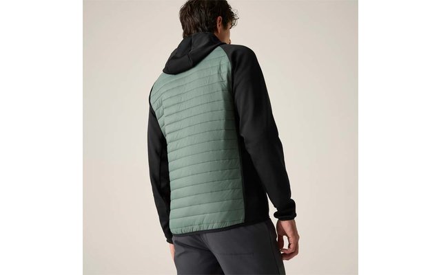 Rückenansicht einer Person in Kapuzenjacke mit hellgrün gestepptem Rückenteil und schwarzen Ärmeln, dunkle Hose, neutraler Hintergrund
