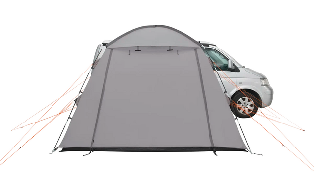 Ein graues Vorzelt ist an der Seite eines weißen Campingbusses befestigt