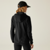 Frau von hinten mit schwarzer Cap, schwarzem Hoodie und schwarzer Hose vor hellem Hintergrund