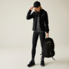 Person in schwarzer Sportkleidung hält schwarzen Rucksack in der Hand
