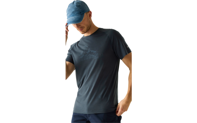 Person mit blauer Kappe, dunkelgrauem T‑Shirt mit Bergmotiv und dunklen Hosen, eine Hand an der Kappe