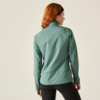 Frau mit roten Haaren trägt eine grüne Jacke, Ansicht von hinten
