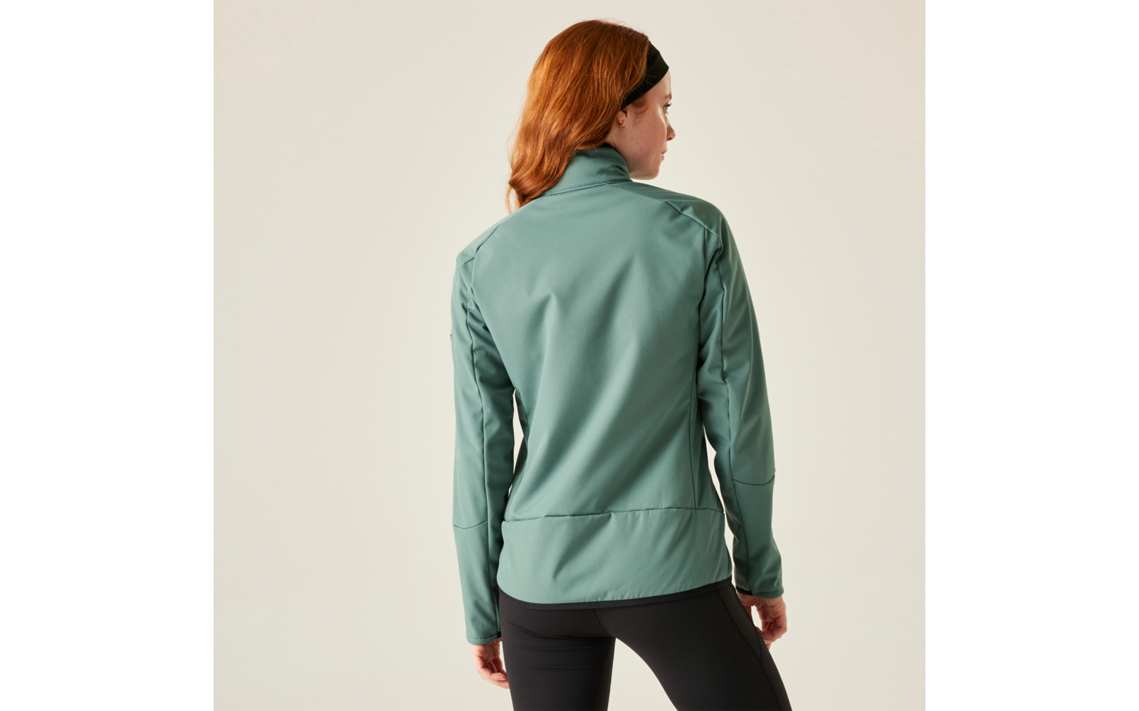 Frau mit roten Haaren trägt eine grüne Jacke, Ansicht von hinten