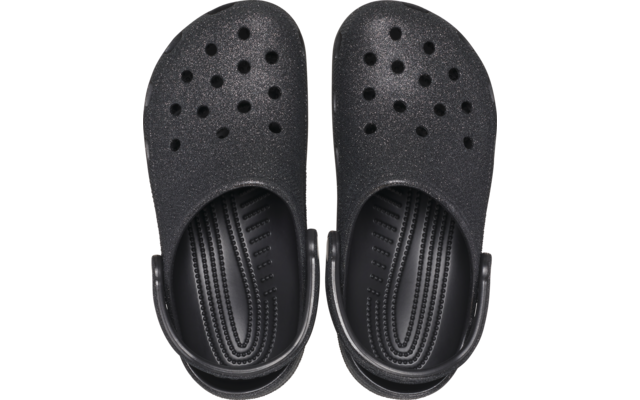 Par de zuecos negros visto desde arriba, con orificios de ventilación y correa trasera