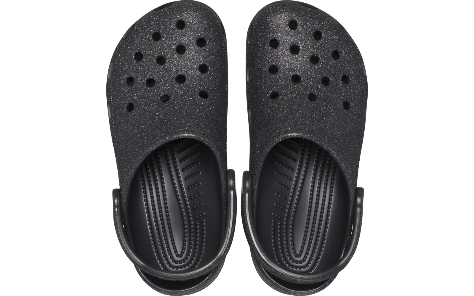 Par de zuecos negros visto desde arriba, con orificios de ventilación y correa trasera