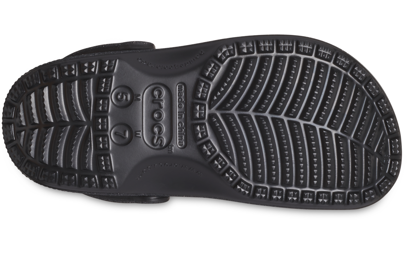 Suela negra de un zueco vista desde abajo, con dibujo del perfil y una correa lateral