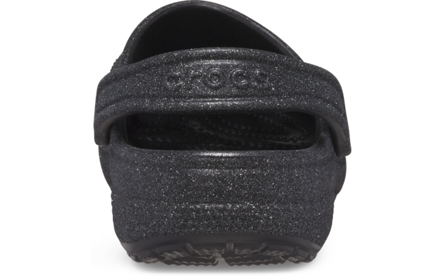Vista trasera de un zueco negro con brillo y correa del talón levantada
