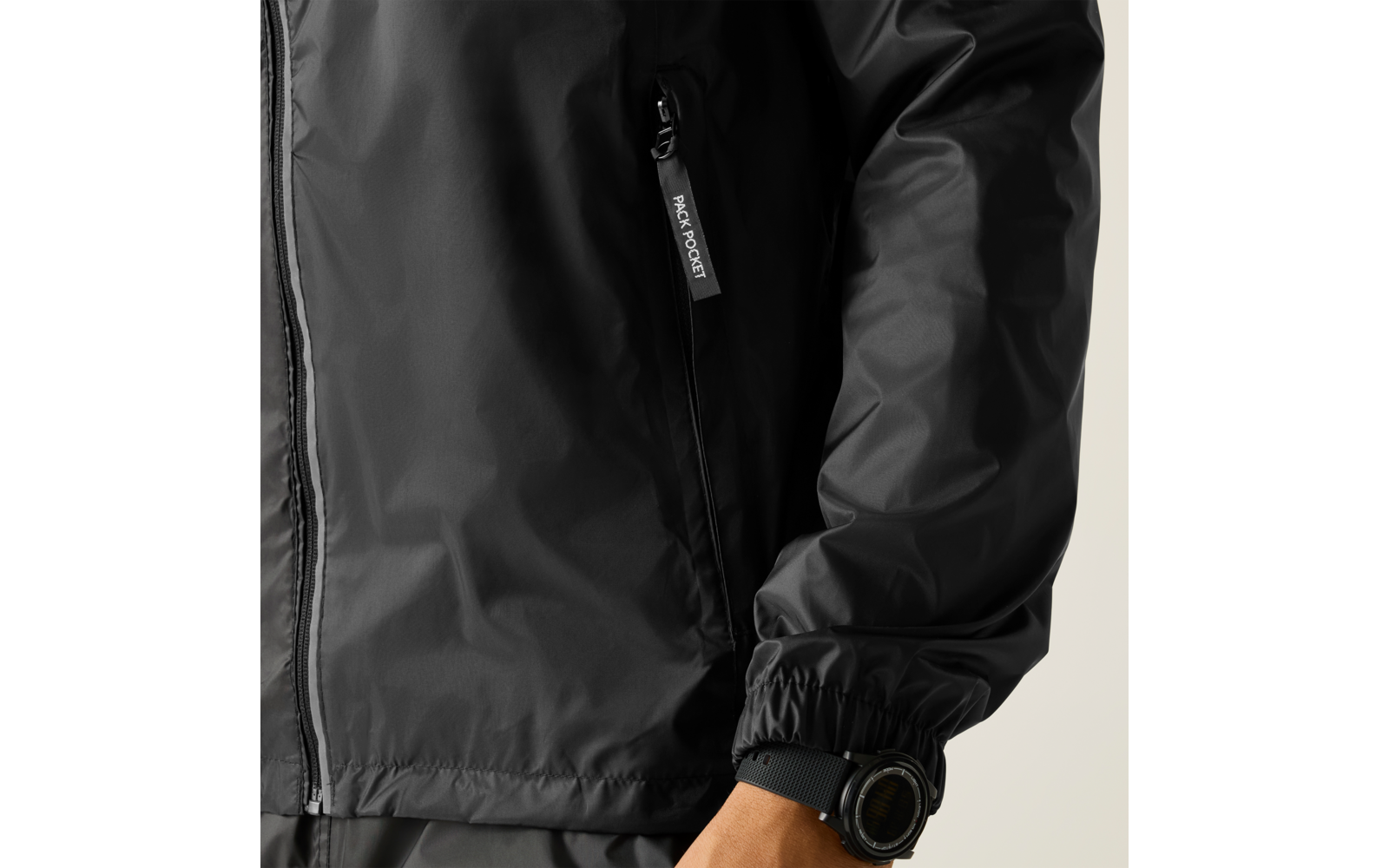 Nahaufnahme einer schwarzen Jackenärmel mit Reißverschlusstasche, elastischer Manschette und Hand mit schwarzer Armbanduhr