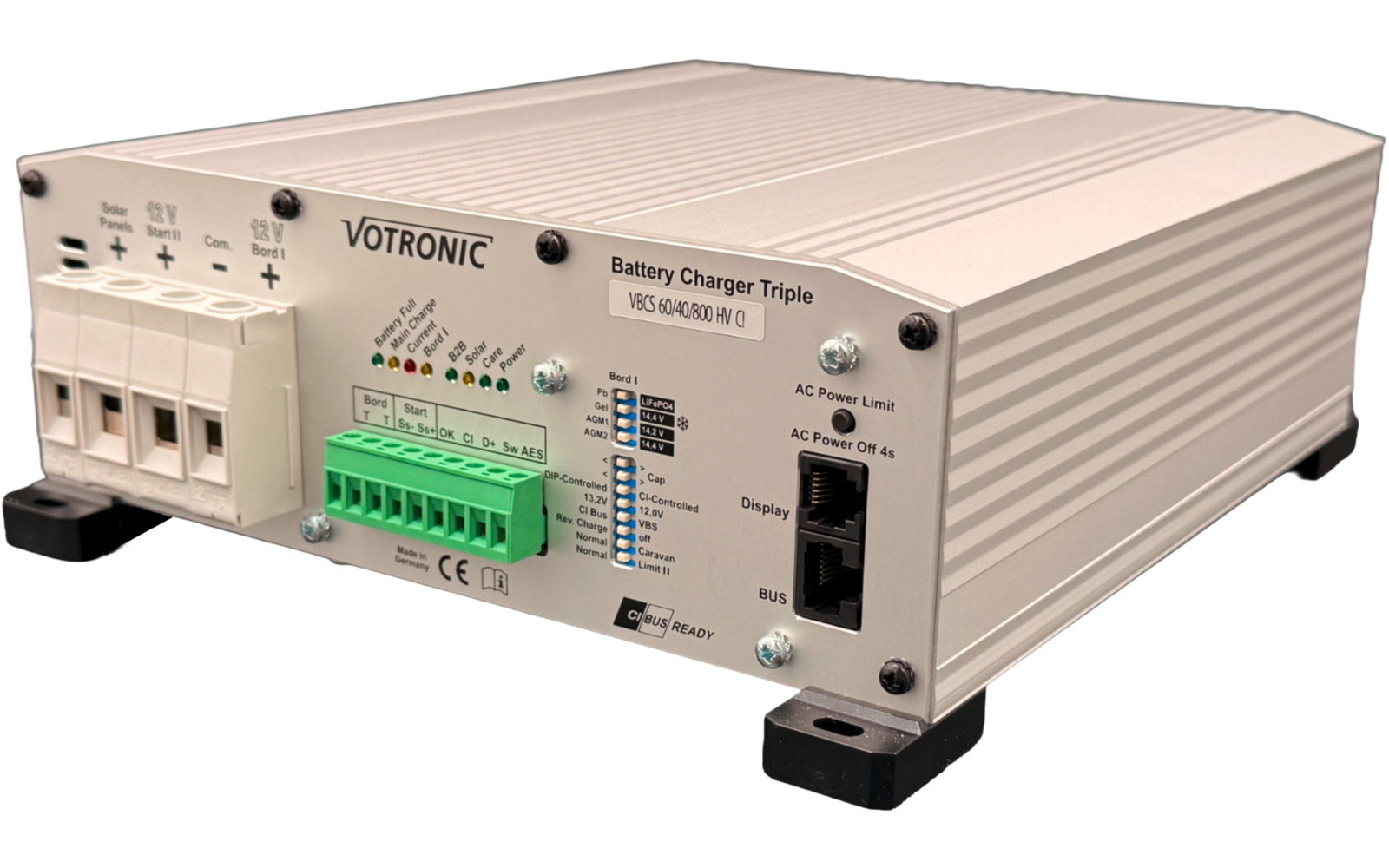 Metallisches, rechteckiges Gerät mit Aufschrift 'VOTRONIC' und 'Battery Charger Triple', mehrere weiße Anschlussklemmen, grüne Klemmenleiste, LED-Anzeigen, zwei RJ45-ähnliche Anschlüsse und schwarze Gummifüße