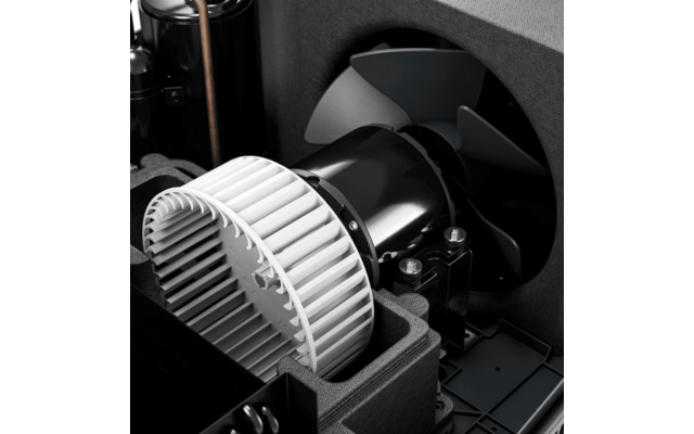 Weißes, zylindrisches Rad mit schmalen Lamellen neben schwarzem Zylinder und dreiblättrigem schwarzem Propeller in schwarzer Kunststoff‑/Schaumstoffeinlage, sichtbare Metallbolzen