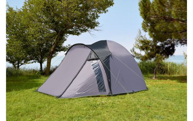 Grijze tent op groen gras onder bomen