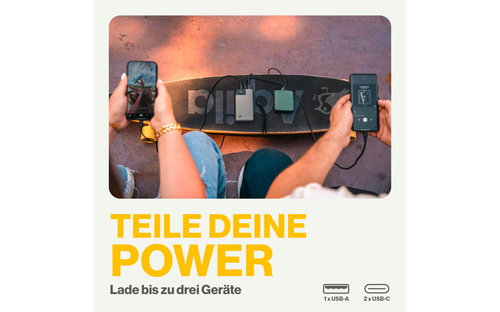 Deux mains tenant chacune un smartphone, avec quatre batteries externes mobiles alignées au centre