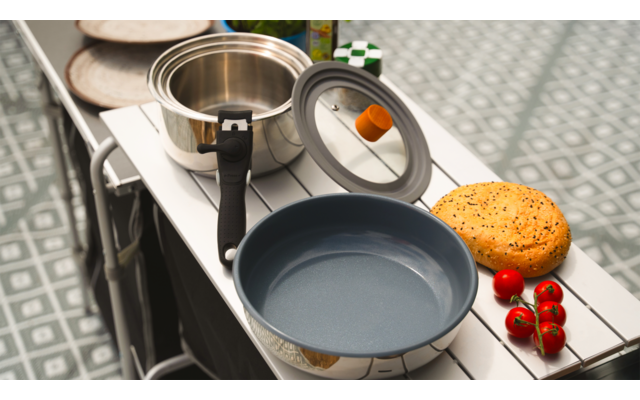 Tisch mit Kaffeetasse, Teekanne, blauem Becher und Gebäck